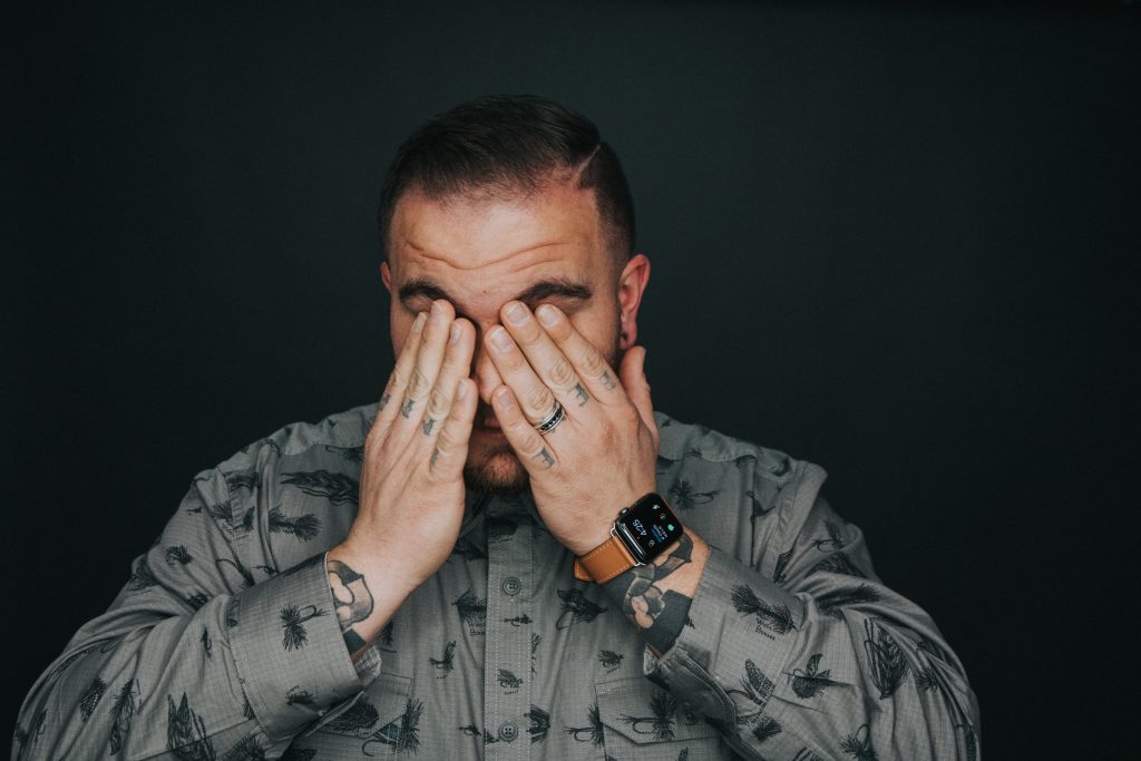 Headache, man covering his eyes