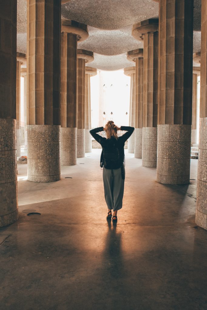 Woman standing in a corridor between pillars