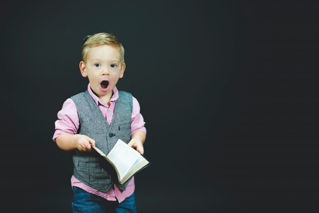 Help with acu-point location - boy wearing gray vest and pink dress shirt holding book