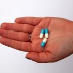 three capsules on person's palm