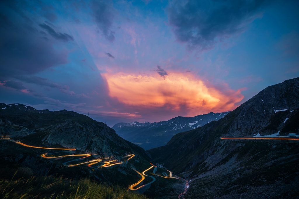 Road up to the mountain pass, an analogy for the effort required to complete the disease process.