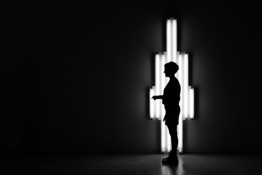 boy standing in front of lamp