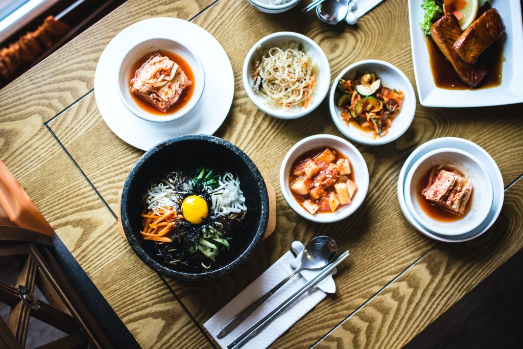 multiple dishes field bowls on table, including fermented kimchi