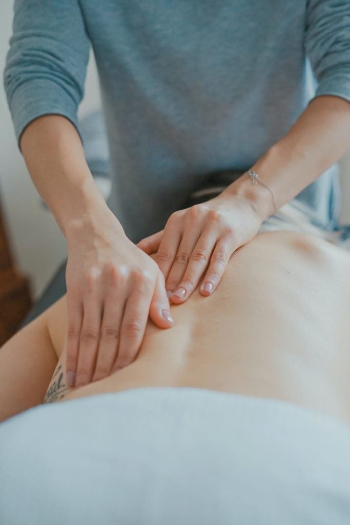 Man massaging woman's back to deal with pain from strain