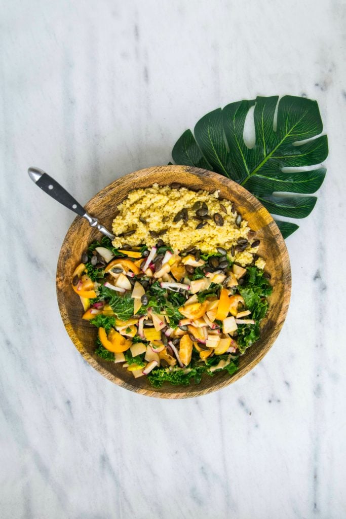Cooked millet (with vegetable salad in brown wooden bowl) is one of your anti-damp heat foods!