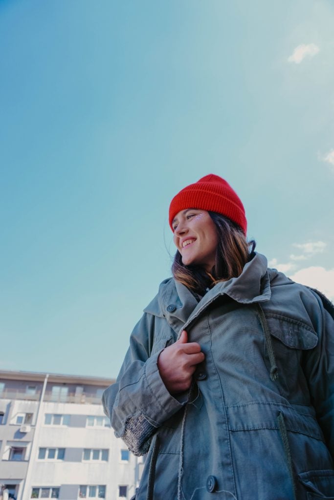woman in gray jacket and red knit cap: warm clothing for Heart Yang deficiency