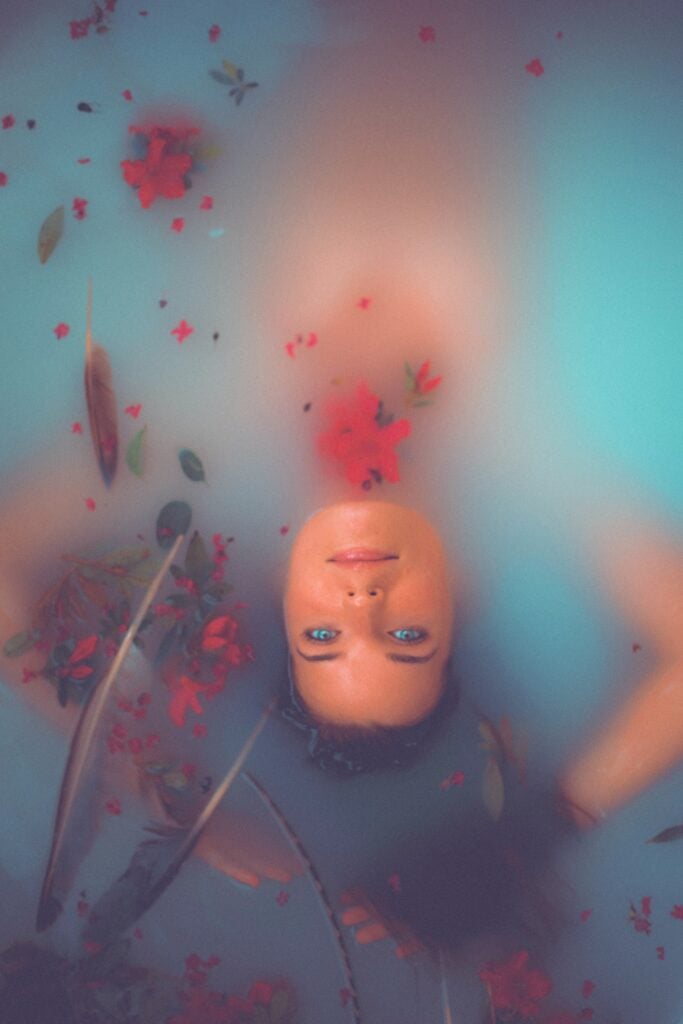woman floating on water: a warm bath before bed in the evening may help you sleep more deeply so improve Liver Blood.