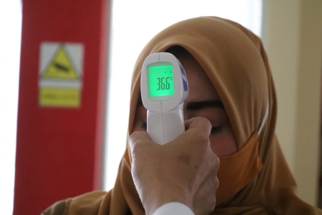 person holding white and gray digital device: welcome a fever!