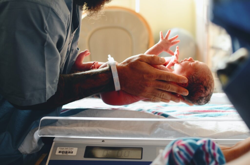 person wearing gray shirt putting baby on scale: bladder 67 for inducing labour