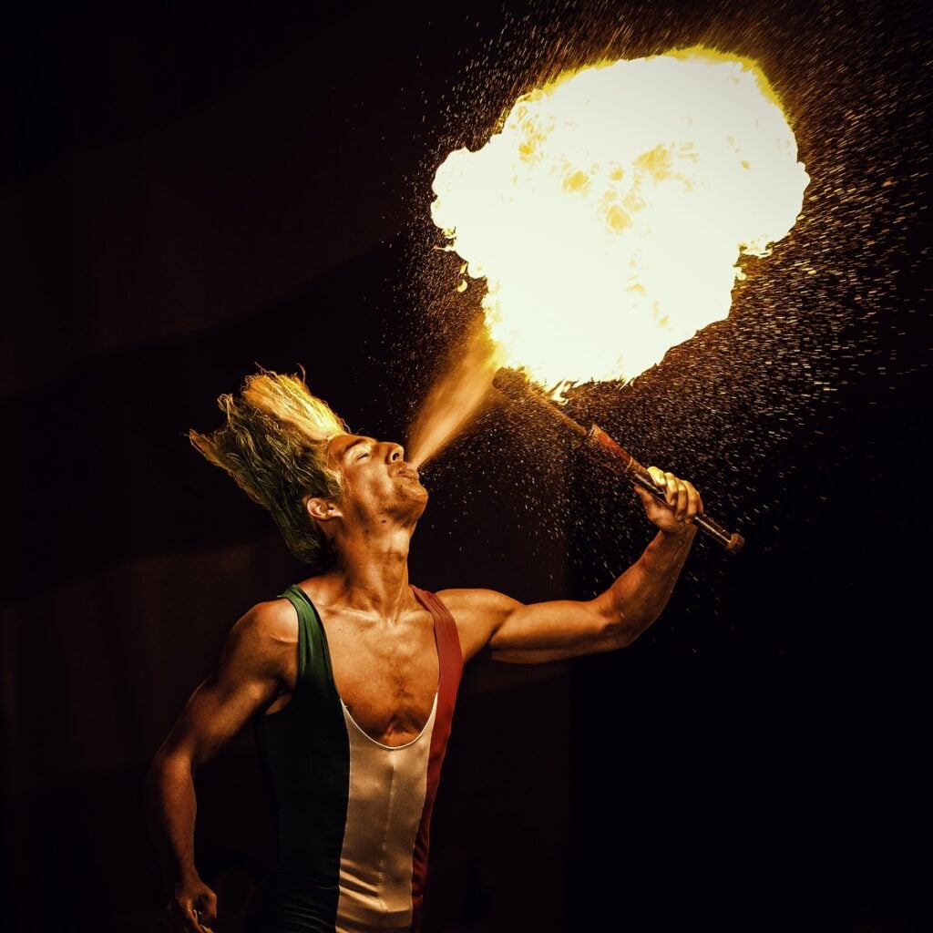 man blowing gas on torch