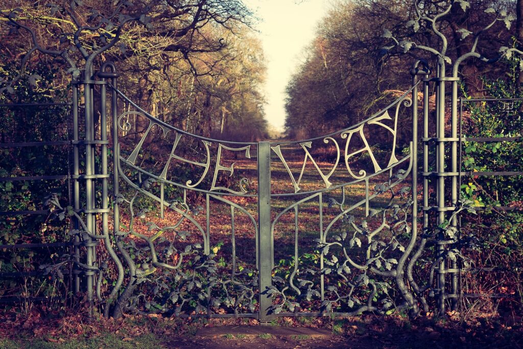 metal element gateway to green trees during daytime
