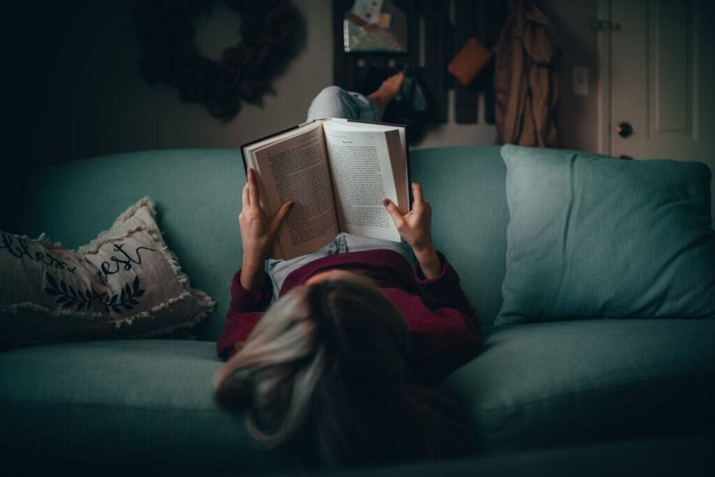 woman in red shirt reading book: a poor position if she has lung yang deficiency!